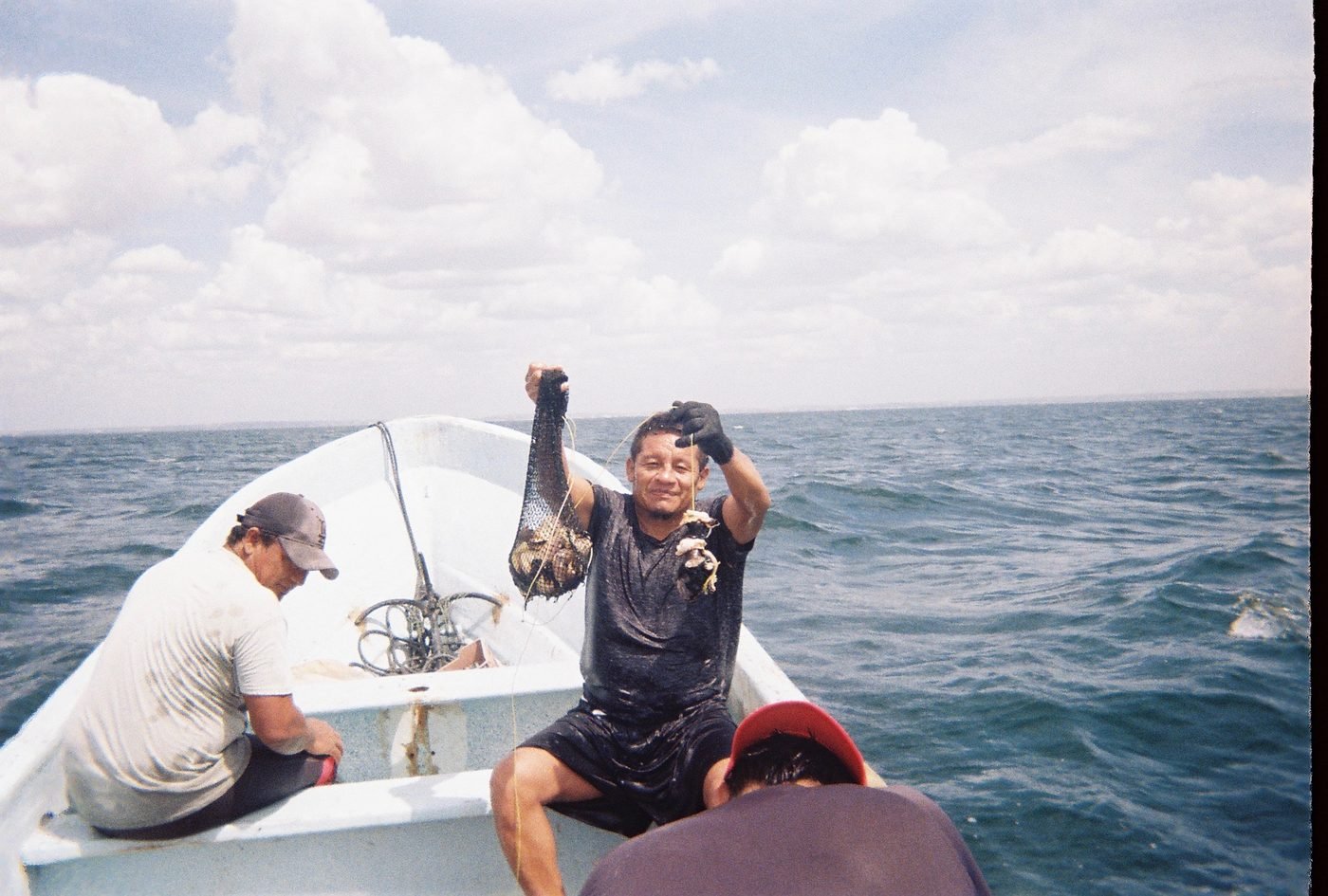 Pescador mostrando la bolsa de red con la captura del día