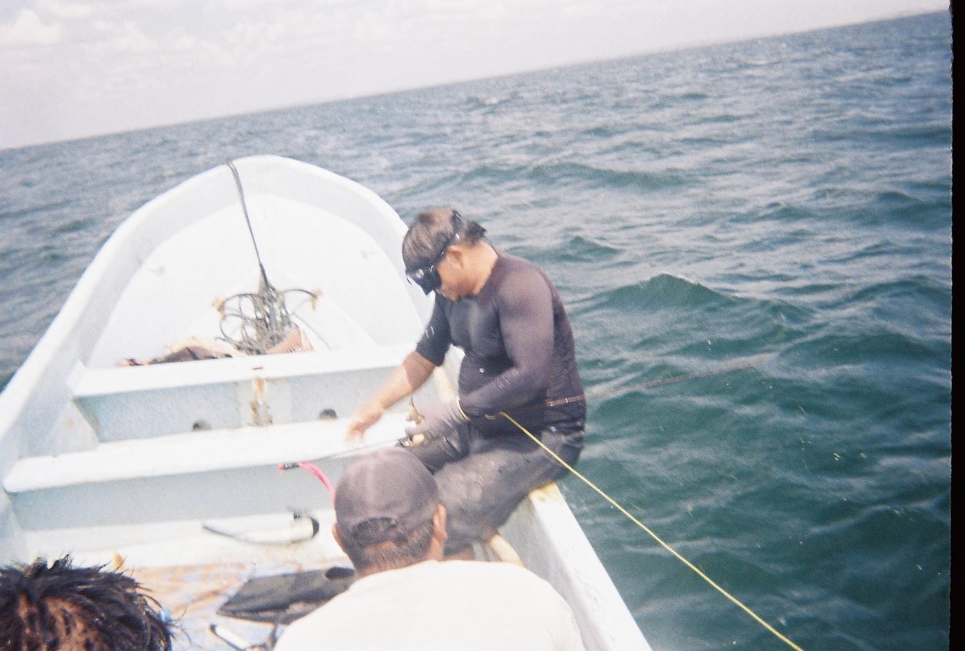 Pescador preparando el equipo en la orilla de la panga antes de bajar